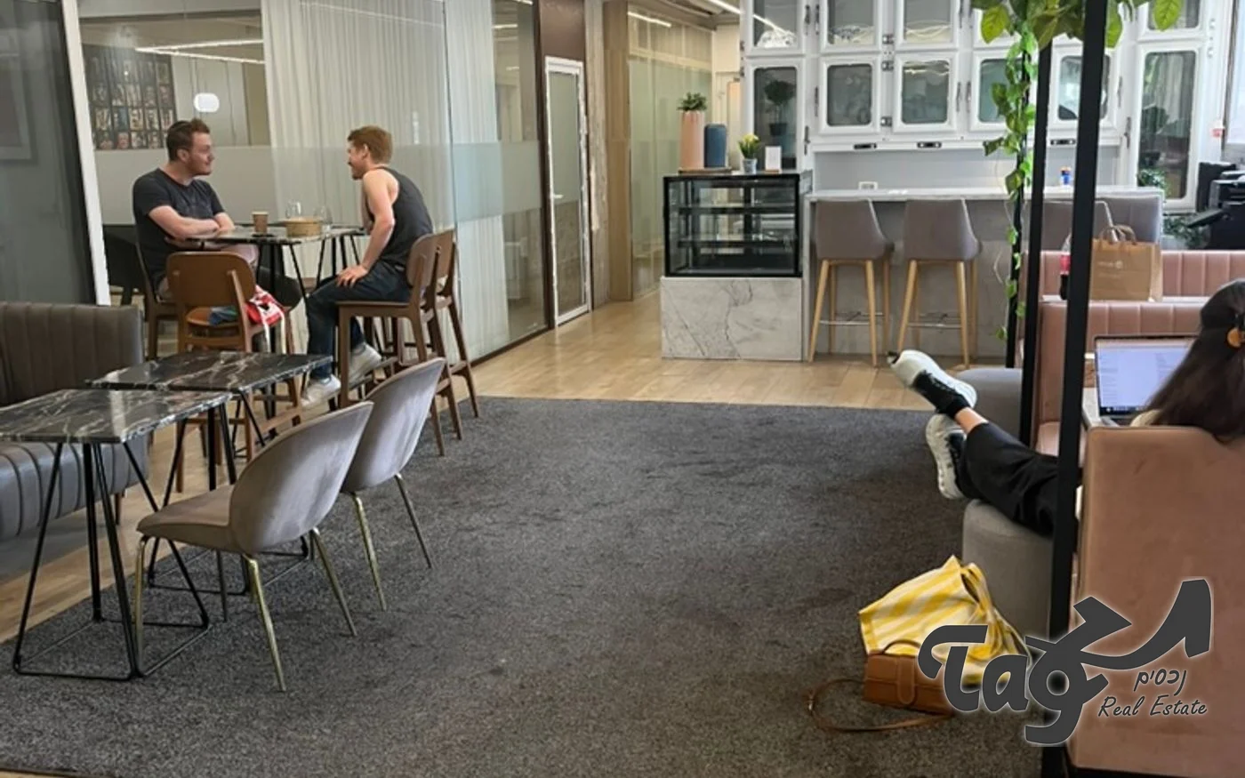 לאונג׳ משותף עם שולחנות קפה, כיסאות ועמדת מטבח