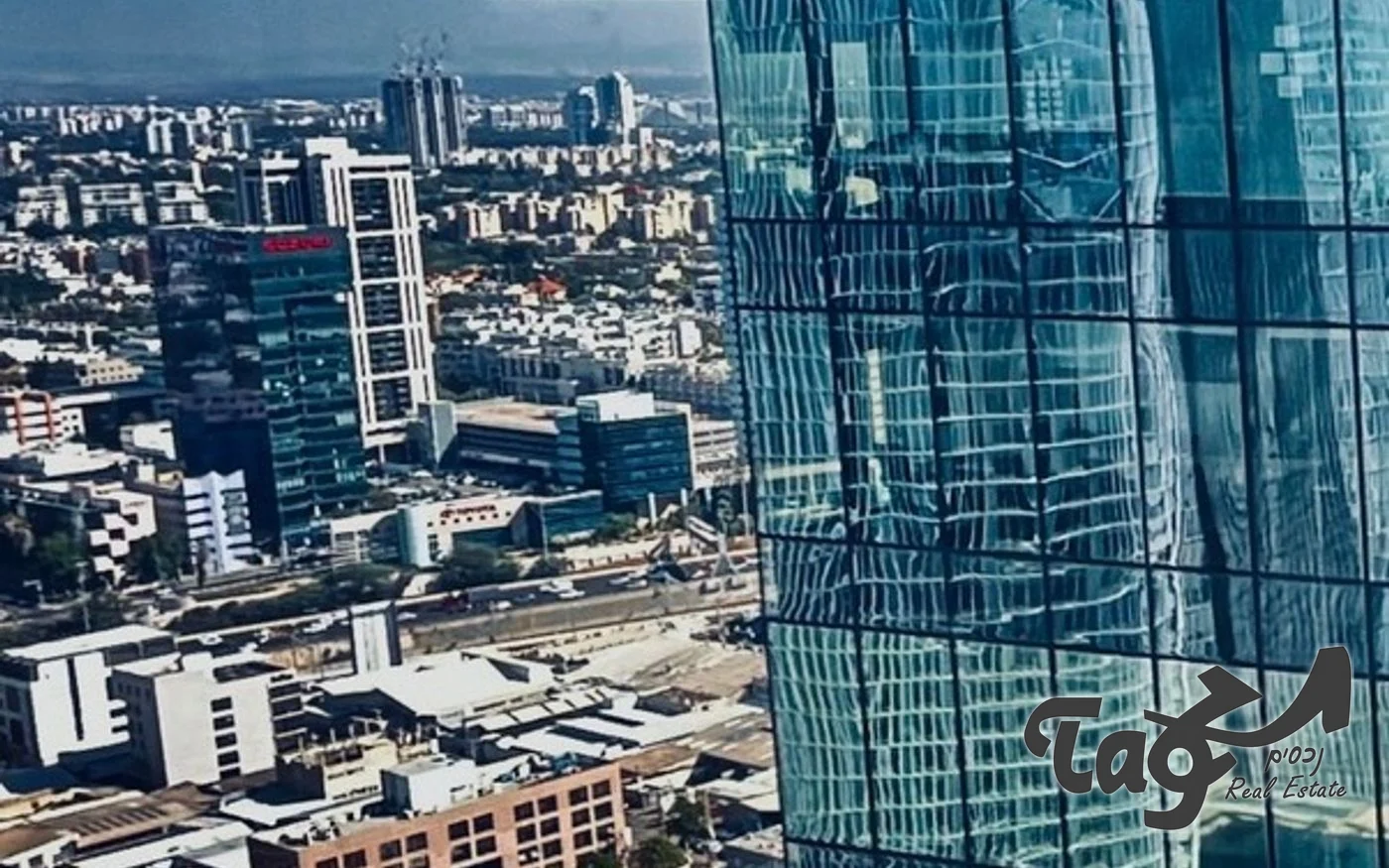 חזית הזכוכית המדורגת של המגדל התאום במגדלי הארבעה, עם השתקפויות ונוף עירוני