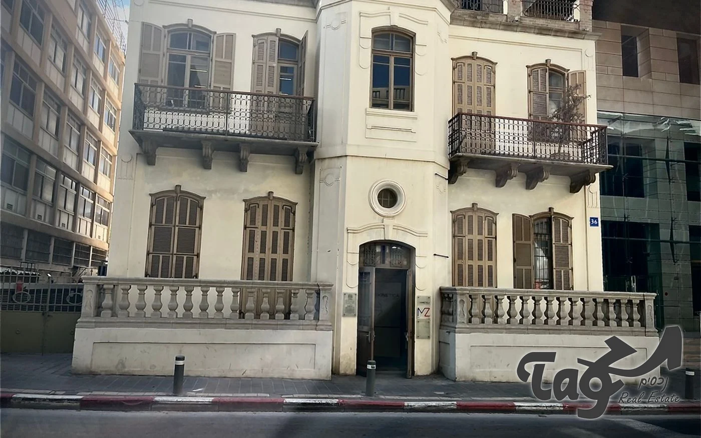 חזית הבניין לשימור: קירות בהירים, מרפסות ברזל ותריסי עץ