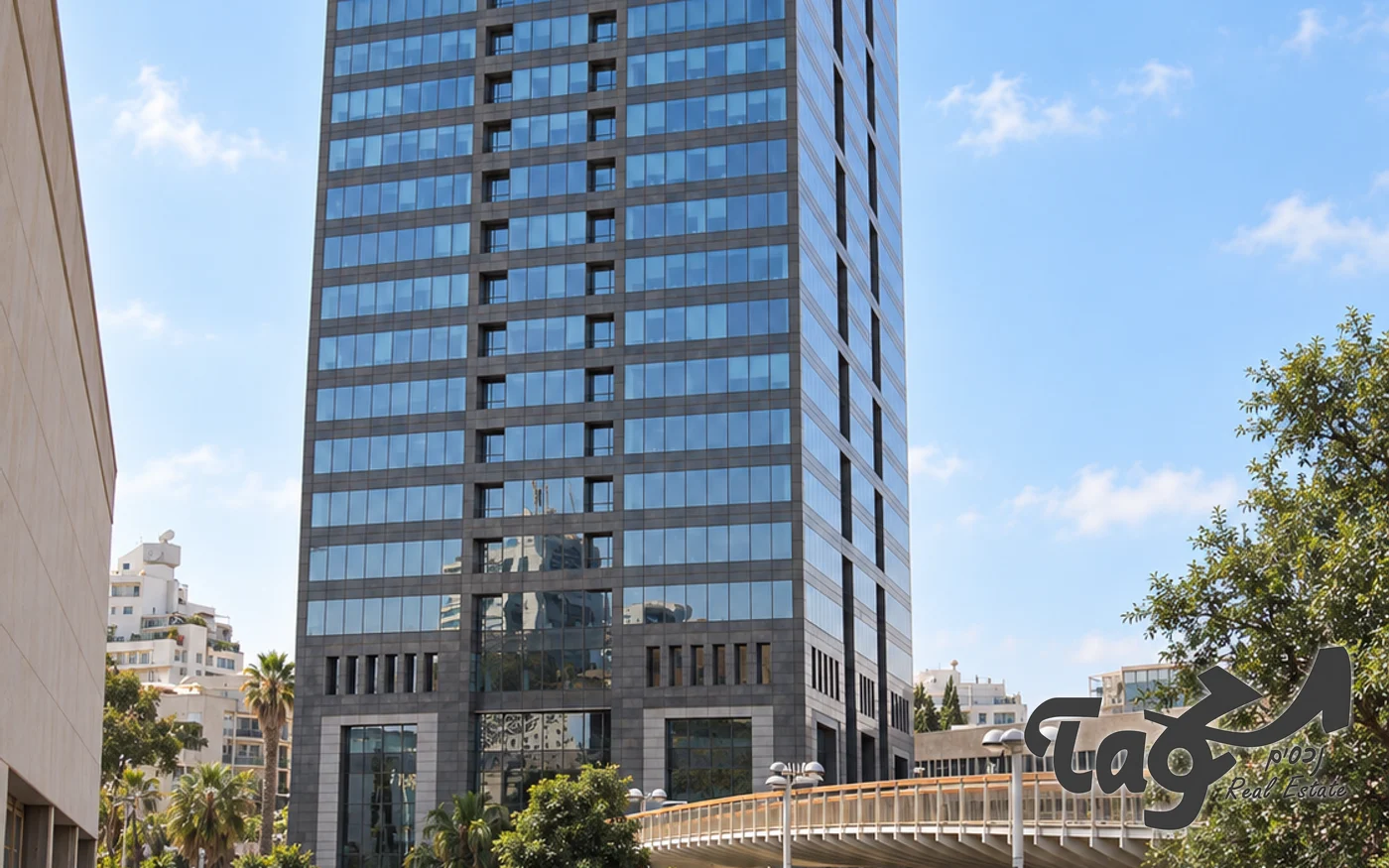 מגדל משרדים גבוה בחזית זכוכית כהה ומסגרת אבן, וגשר להולכי רגל לידו