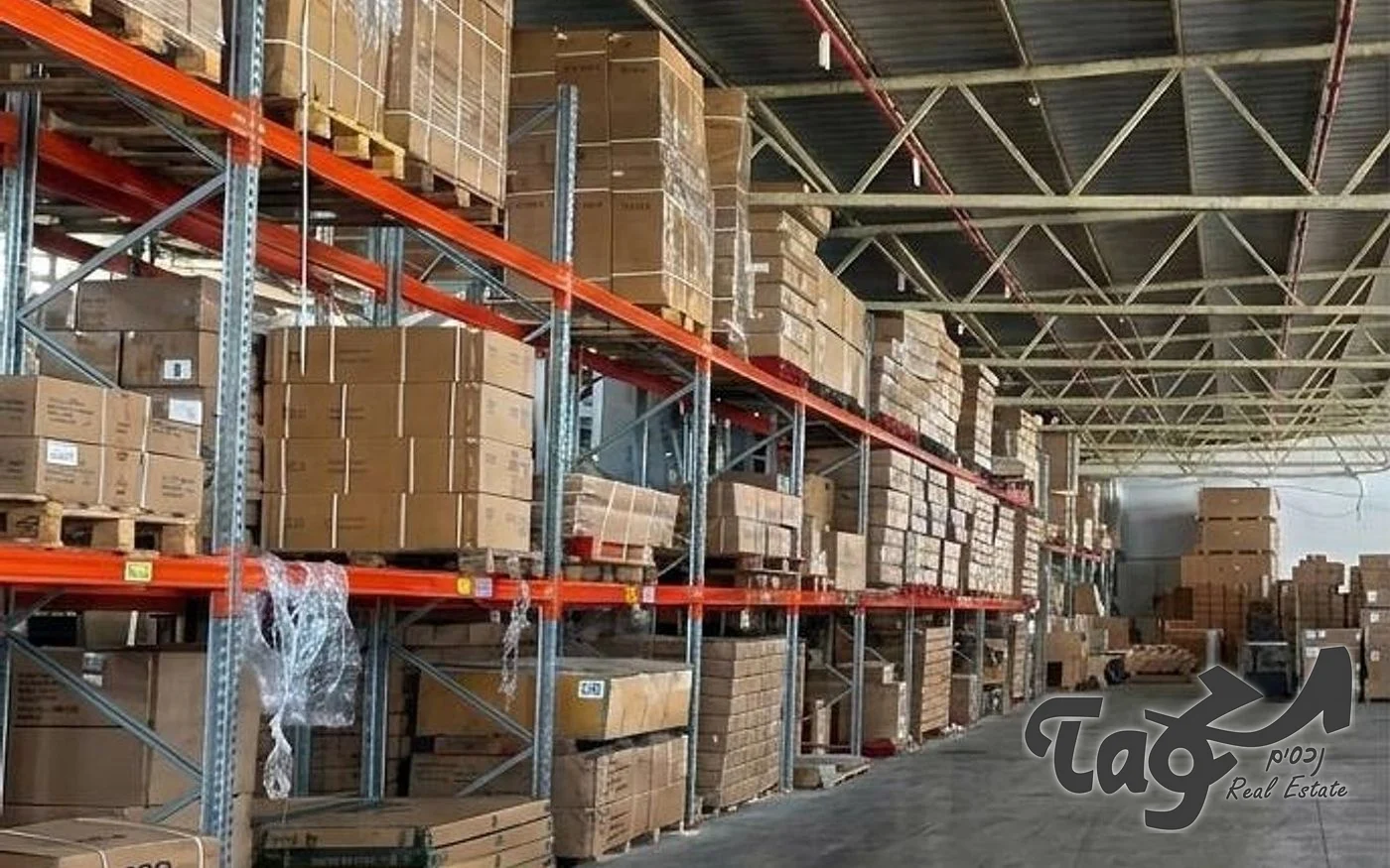 פנים מחסן עם מדפי משטחים עמוסים בארגזים ותקרת קורות פלדה