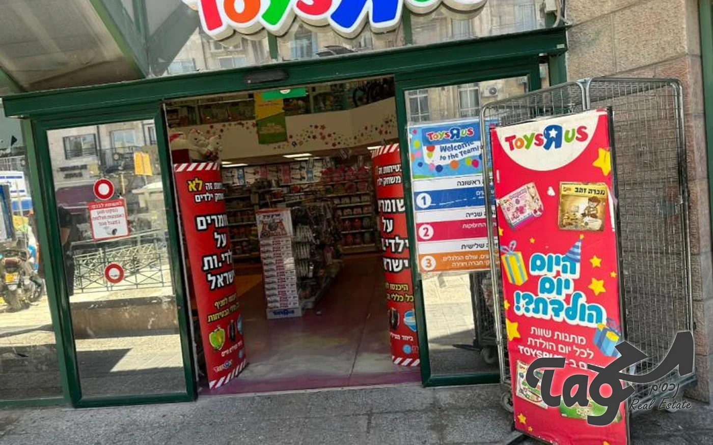 כניסה לחנות צעצועים בקומת הקרקע, עם שלטים צבעוניים