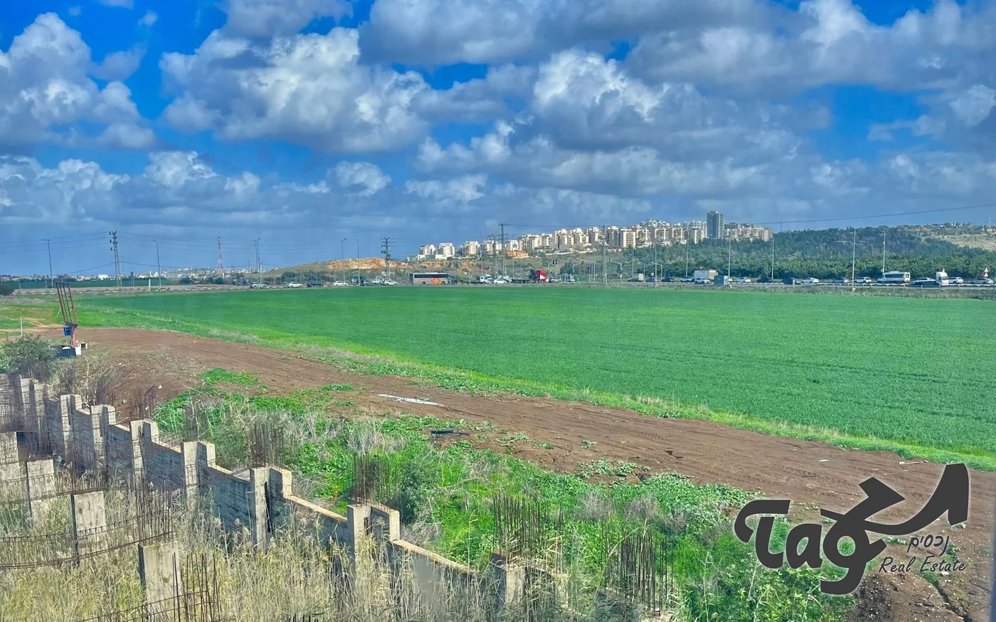 מגרש פתוח ליד כביש ראשי: שדה ירוק, ובאופק שכונות מגורים על רכס