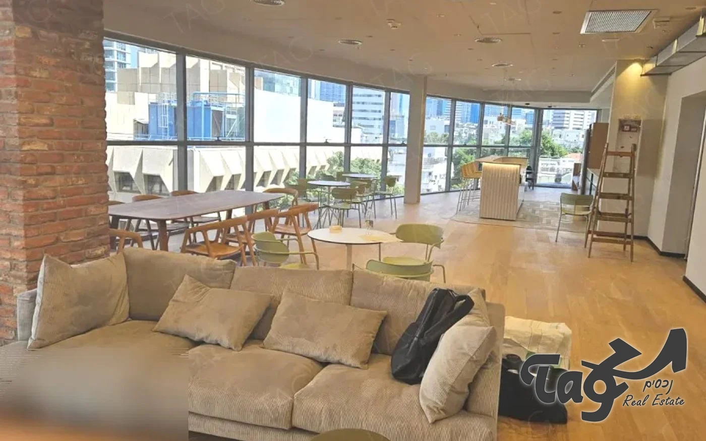 לאונג׳ עם ספה גדולה לאורך קיר החלונות