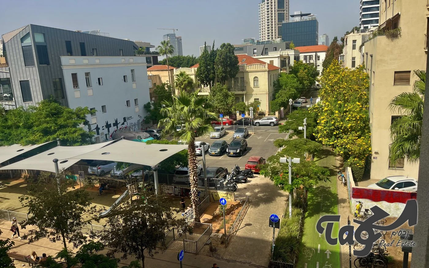 מבט מהמשרד על פארק המסילה, בתים לשימור ומגדלי העיר ברקע