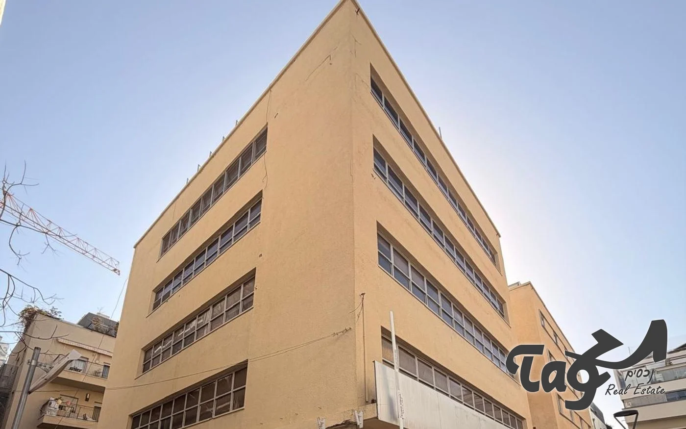 בניין המשרדים בבית השואבה: חזית טיח בגוון חול וחלונות סרט ארוכים