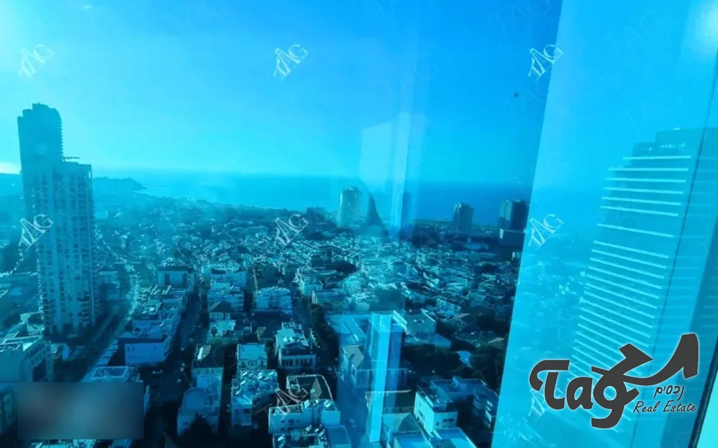נוף אווירי על בתי תל אביב והים מחלון הקומה הגבוהה