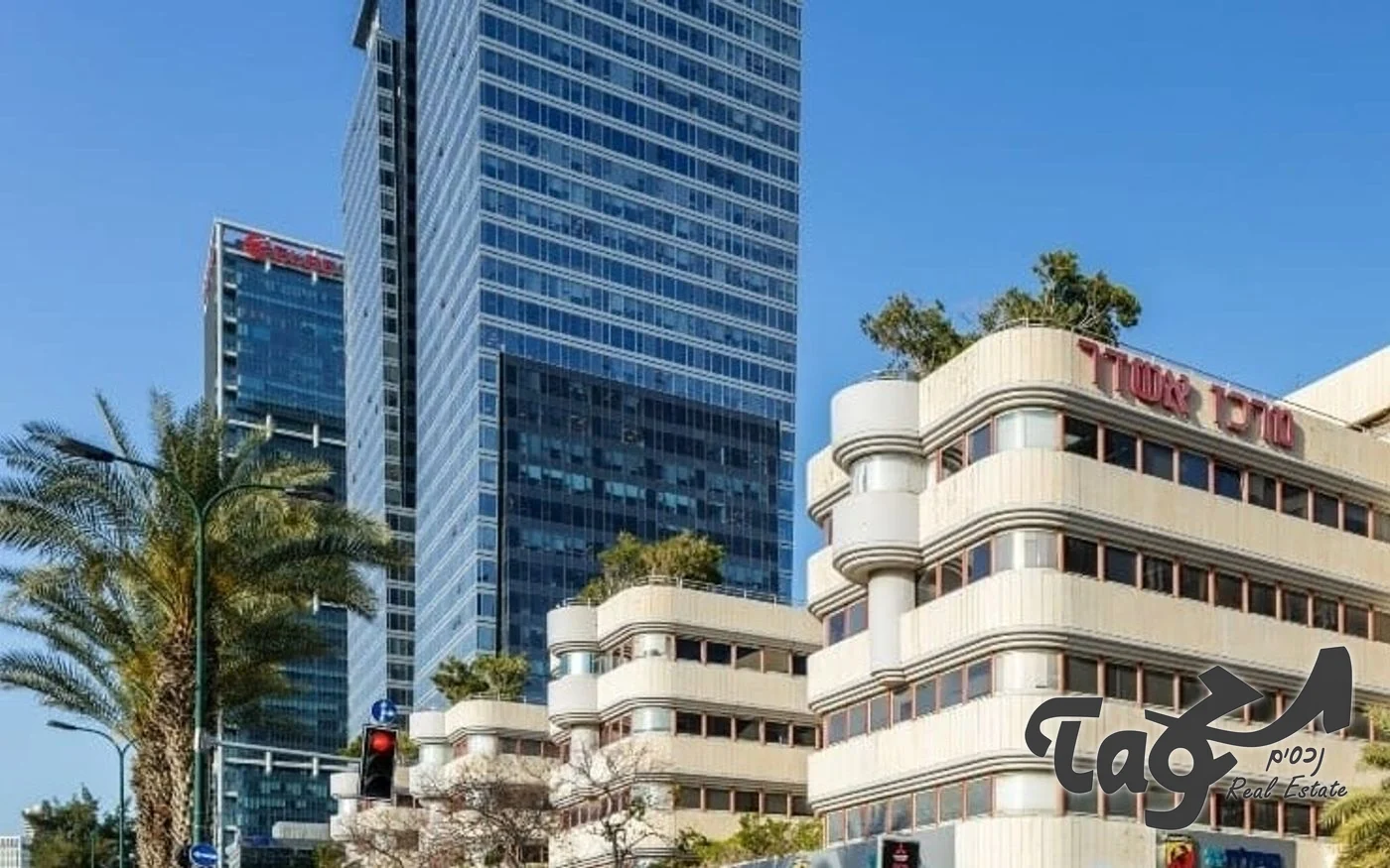 בניין המשרדים ביגאל אלון: חזית בגוון בז׳ עם חלונות סרט ומגדלי משרדים ברקע